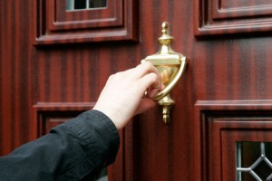 ADW55K mans hand using door knocker on wood effect upvc door cold calling household